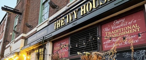 The Ivy House, Nunhead The Ivy House is a community-run pub in South East London. The image shows the front of the pub, with hanging baskets of flowers and chalkboards advertising the pub's hours.